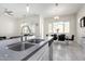 Bright kitchen and dining area with stainless steel sink and faucet set under large windows for a naturally lit space at 20496 W Valley View Dr, Buckeye, AZ 85396