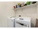 Laundry room featuring modern white front-loading washer and dryer and shelf storage above at 20496 W Valley View Dr, Buckeye, AZ 85396