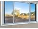 Scenic view of a backyard through a window, showing trees and open space at 22859 W Euclid Ave, Buckeye, AZ 85326