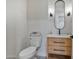 Stylish powder room with wood vanity, oval mirror, and toilet at 22859 W Euclid Ave, Buckeye, AZ 85326