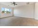 Bright bedroom with large window, ceiling fan, and neutral wall colors at 22859 W Euclid Ave, Buckeye, AZ 85326