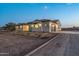 Exterior view of a craftsman style home with stone accents at dusk at 22859 W Euclid Ave, Buckeye, AZ 85326