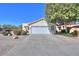 Single story house with white exterior, two car garage, and desert landscaping at 2490 E Fiesta Dr, Casa Grande, AZ 85194