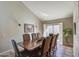 Bright dining room with a large wooden table and access to a patio at 26409 S Moonshadow Dr, Sun Lakes, AZ 85248