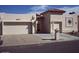 Tan two-car garage stucco home with a Spanish-style tile roof at 26409 S Moonshadow Dr, Sun Lakes, AZ 85248