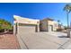 Front view of a tan house with a two-car garage and desert landscaping at 26409 S Moonshadow Dr, Sun Lakes, AZ 85248