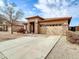 One-story house with a tan stucco exterior, stone accents, and a two-car garage at 2706 N 115Th Dr, Avondale, AZ 85392