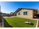 Spacious backyard with artificial turf, patio furniture, and cornhole game at 2707 N Acacia Way, Buckeye, AZ 85396