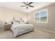 Comfortable bedroom with a ceiling fan and large window at 2707 N Acacia Way, Buckeye, AZ 85396