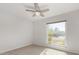 Bright bedroom with ceiling fan, large window, and neutral carpeting at 2728 E Encanto Cir, Mesa, AZ 85213