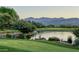 Serene landscape with a pond, mountains, and lush greenery at 27506 N Montana Dr, Rio Verde, AZ 85263