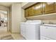 Bright laundry room with washer, dryer, and built-in cabinets at 27506 N Montana Dr, Rio Verde, AZ 85263