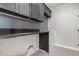 Laundry room with dark cabinetry, patterned tile, and a utility sink at 3040 N Point Ridge Rd, Buckeye, AZ 85396