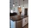 Modern kitchen island with dark countertop and stainless steel dishwasher at 3094 N 195Th Dr, Buckeye, AZ 85396