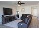 Living room with sectional sofa, large TV, and adjacent kitchen at 3094 N 195Th Dr, Buckeye, AZ 85396