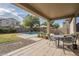 Covered patio with seating area, adjacent to a refreshing pool and lush lawn at 3151 E Turnberry Dr, Gilbert, AZ 85298