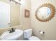 Elegant bathroom with a pedestal sink, toilet, and decorative mirror at 3151 E Turnberry Dr, Gilbert, AZ 85298