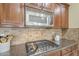 Modern gas cooktop and microwave in kitchen with granite counters and wood cabinets at 3151 E Turnberry Dr, Gilbert, AZ 85298