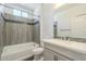 Modern bathroom with grey tile, bathtub, and updated vanity at 316 E Leverenz Ave, Queen Creek, AZ 85140