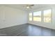 Well-lit bedroom with large windows and wood-look tile floors at 316 E Leverenz Ave, Queen Creek, AZ 85140