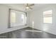 Bright bedroom with wood-look floors, ceiling fan, and window seat at 316 E Leverenz Ave, Queen Creek, AZ 85140