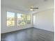 Bright room with gray tile floors, three windows, and ceiling fan at 316 E Leverenz Ave, Queen Creek, AZ 85140