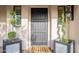 Dark gray front door flanked by potted plants at 32633 N 137Th St, Scottsdale, AZ 85262