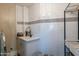 Laundry room with white tile, a utility sink, and built-in shelving at 32633 N 137Th St, Scottsdale, AZ 85262