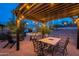 Pergola-covered patio with dining table and string lights at 32633 N 137Th St, Scottsdale, AZ 85262