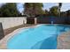 Freeform swimming pool with safety fence and stone feature at 3432 E Bartlett Dr, Gilbert, AZ 85234