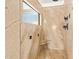 Spa-like shower with marble walls, built-in seat, and window at 3947 N Carnation Ln, Avondale, AZ 85392