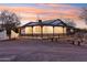 One-story home with a long covered porch, dark railings, and gravel driveway at 4205 E Peak View Rd, Cave Creek, AZ 85331