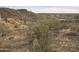 View of a desert lot with sparse vegetation and distant homes at 46312 N 38Th Ave, New River, AZ 85087