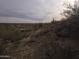 View of a desert lot with sparse vegetation and distant homes at 46312 N 38Th Ave, New River, AZ 85087