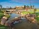 Landscaped pond with a waterfall feature and community clubhouse in background at 4802 S Duffy --, Mesa, AZ 85212