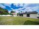 Spacious backyard featuring an outdoor kitchen, lush lawn, and desert trees at 4916 E Kathleen Rd, Scottsdale, AZ 85254
