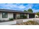 Home exterior featuring desert landscaping, a black garage door, modern front door and a white stucco facade at 4916 E Kathleen Rd, Scottsdale, AZ 85254