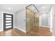 Modern hallway featuring a glass wine cellar, hardwood floors, and neutral paint at 4916 E Kathleen Rd, Scottsdale, AZ 85254