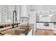A modern kitchen features white cabinetry, stainless appliances, and a large black granite island at 4916 E Kathleen Rd, Scottsdale, AZ 85254