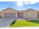 Single-story house with a two-car garage and well-manicured lawn at 4933 W Melody Ln, Laveen, AZ 85339