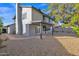 House's rear elevation, showcasing a covered patio and a gravel backyard at 5344 W Desert Hills Dr, Glendale, AZ 85304