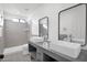 Modern bathroom with double vanity, gray tile, and walk-in shower at 5344 W Desert Hills Dr, Glendale, AZ 85304