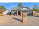 Brick ranch home with gray exterior, black garage door, and landscaped yard at 5344 W Desert Hills Dr, Glendale, AZ 85304