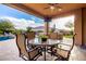 Covered patio with dining table and chairs, adjacent to the pool at 5429 E Barwick Dr, Cave Creek, AZ 85331