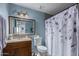 Bathroom with shower/tub combo, wood vanity, and patterned shower curtain at 5934 W Coronado Rd, Phoenix, AZ 85035