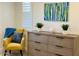 Stylish bedroom with mustard yellow chair and large dresser at 6231 E Mark Way # 32, Cave Creek, AZ 85331