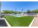 Landscaped backyard with pool, artificial turf and trampoline at 630 W Echo Ln, Phoenix, AZ 85021