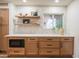 Kitchen features white tile backsplash and light wood cabinets with shelving at 6425 N 79Th St, Scottsdale, AZ 85250