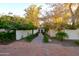 Inviting entry to a Spanish-style home with a brick pathway, lush landscaping, and white walls at 7249 N Central Ave, Phoenix, AZ 85020