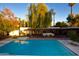 Large rectangular pool with spacious patio and surrounding trees at 7249 N Central Ave, Phoenix, AZ 85020